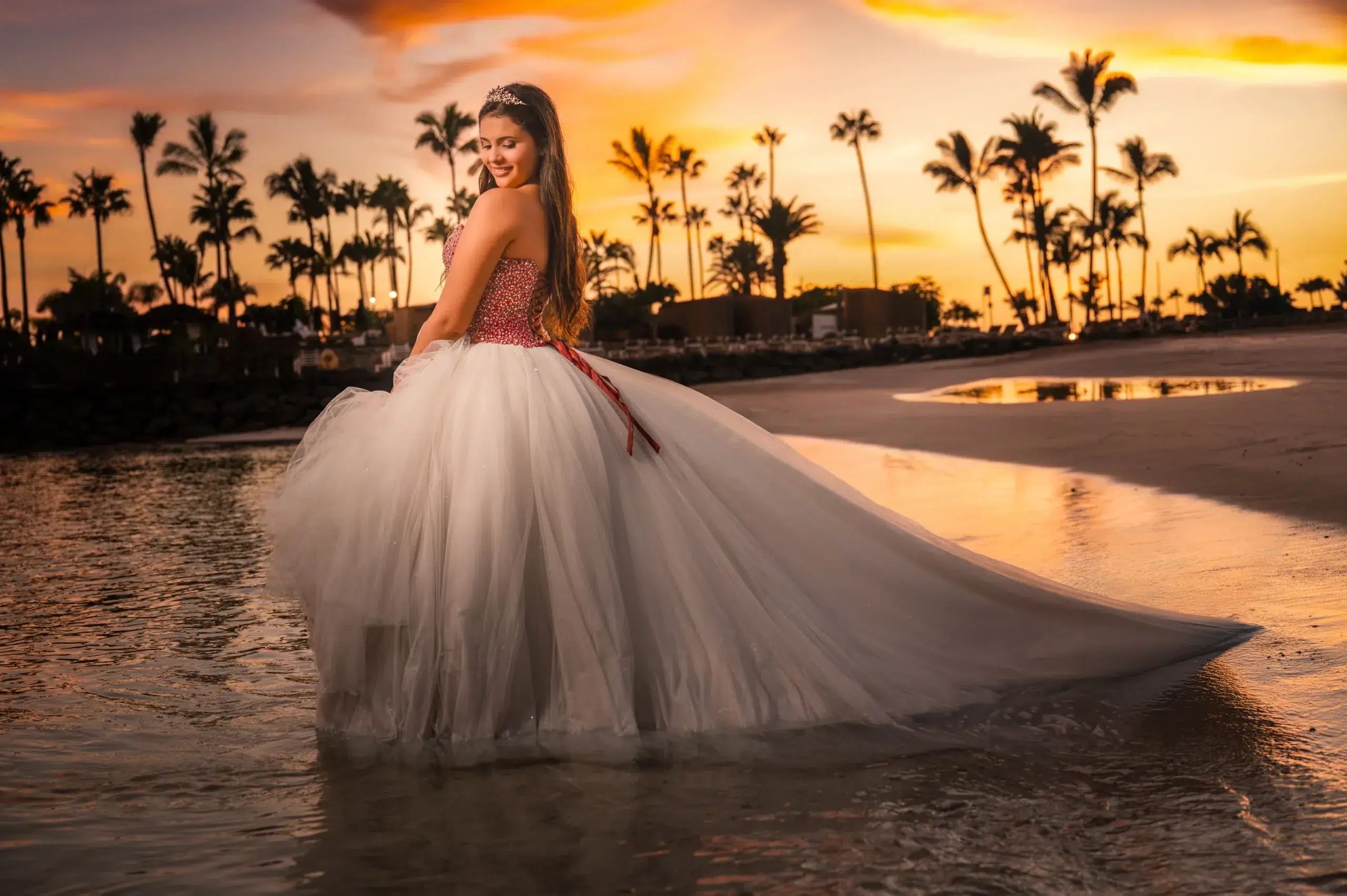 Joven con vestido de quince años en una playa al atardecer.